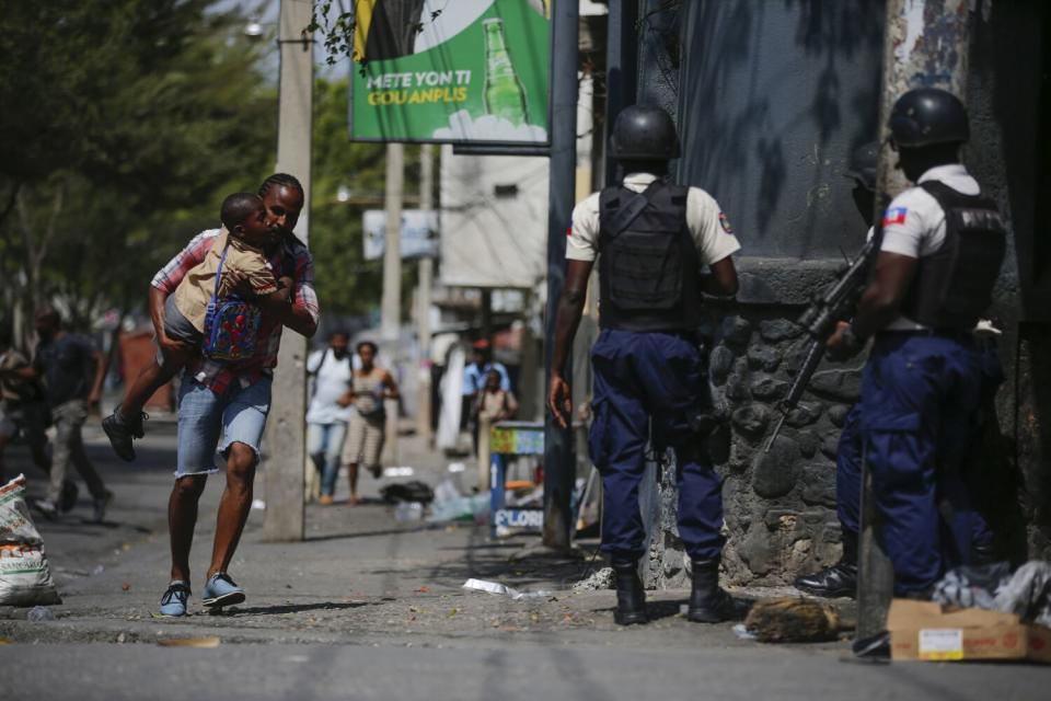 A man carrying a child runs past police.