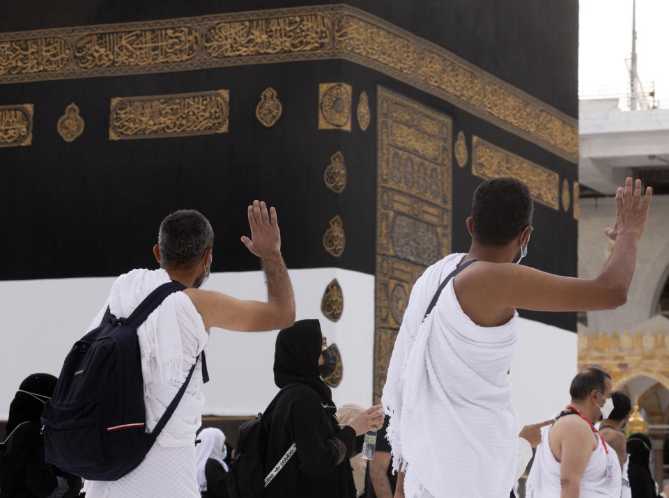 Muslim pilgrims pray in front of the Kaaba, the cubic building at the Grand Mosque, as they wear masks and keep social distancing, a day before the annual hajj pilgrimage, Saturday, July 17, 2021. The pilgrimage to Mecca required once in a lifetime of every Muslim who can afford it and is physically able to make it, used to draw more than 2 million people. But for a second straight year it has been curtailed due to the coronavirus with only vaccinated people in Saudi Arabia able to participate. (AP Photo/Amr Nabil)