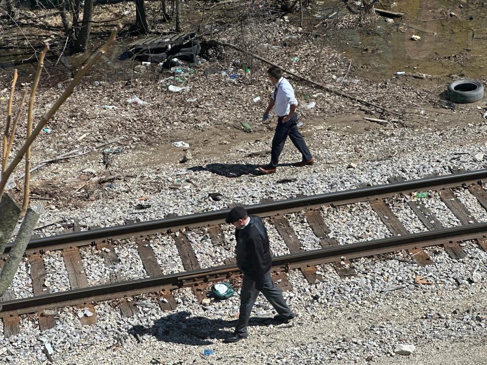 Two Milwaukee police detectives search along the train tracks near North 30th and West Galena streets on Monday, April 8.