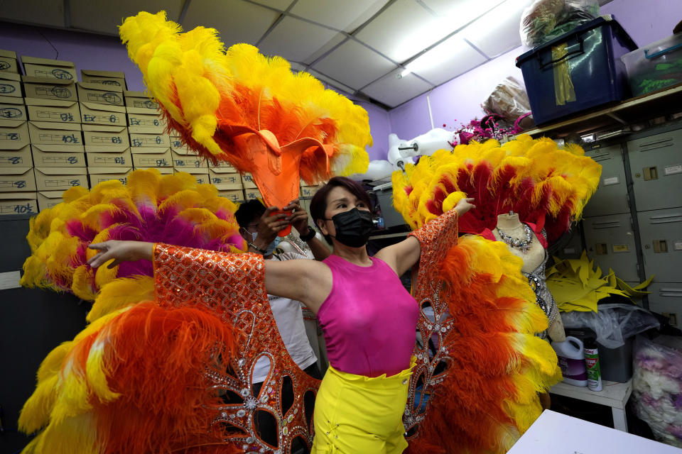 Costume manager Supat Kuntatun wears a new performance costume at the Phuket Simon Cabaret in Phuket, southern Thailand, Tuesday, June 29, 2021. Thailand's government will begin the Phuket Sandbox scheme to bring the tourists back to Phuket starting July 1. The cabaret will not open immediately but its dancers might start with smaller shows in hotels and restaurants until larger number of tourists start to arrive. (AP Photo/Sakchai Lalit)