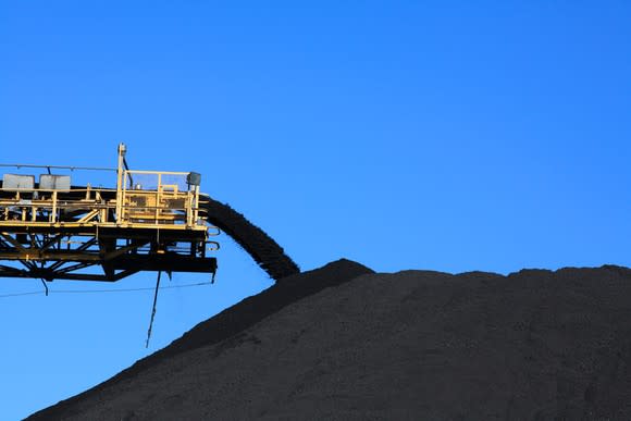 A conveyor system adding coal to a large pile.