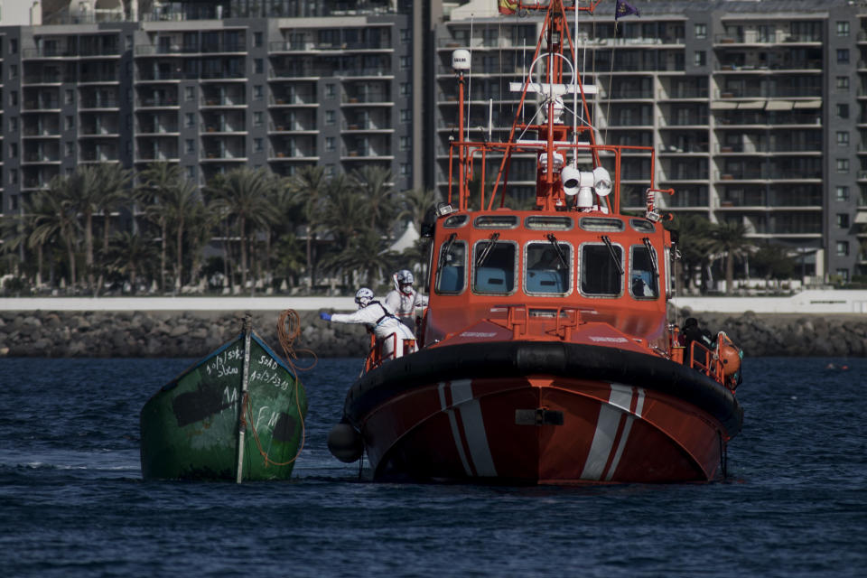 Spanish coastguards arrive in Arguineguin carrying migrants after their rescue in Gran Canaria island, Spain on Wednesday Nov. 25, 2020. Spanish rescue services said Wednesday at least seven people died after a migrant boat carrying more than 30 people hit rocks close to a small port on the Canary Island of Lanzarote. Many of the rescued were taken to the Arguineguín dock on the southwestern coast of Gran Canaria island, where several thousand people of different origin are being kept, some in tents. (AP Photo/Javier Fergo)