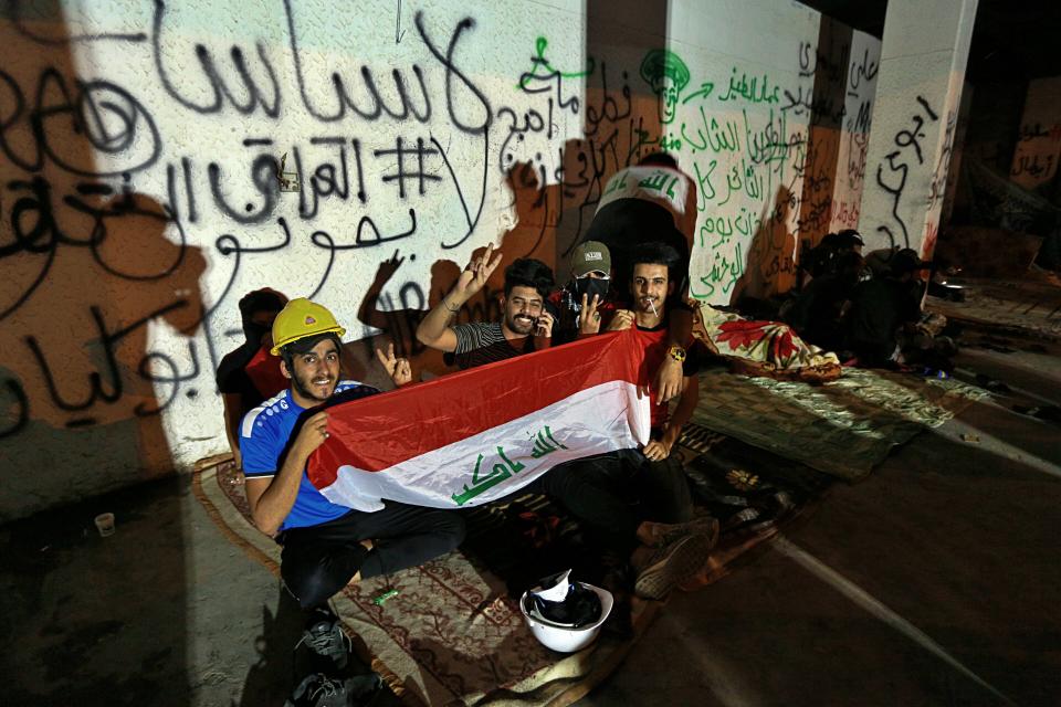 In this Oct. 31, 2019, photo, Iraqi anti-government protesters spend the night in a building near Tahrir Square, Baghdad, Iraq. An abandoned building in central Baghdad has emerged as the epicenter of anti-government protests in Iraq, with hundreds holed up inside. The Saddam Hussein-era building known as the “Turkish Restaurant” overlooks Tahrir Square, the Tigris River and the Green Zone, and protesters who took it over on Oct. 25 have sworn not to leave it. (AP Photo/Hadi Mizban)