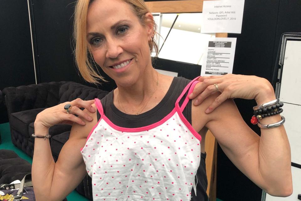 Sheryl Crow holding an item of her clothing which she has donated to Oxfam (PA)