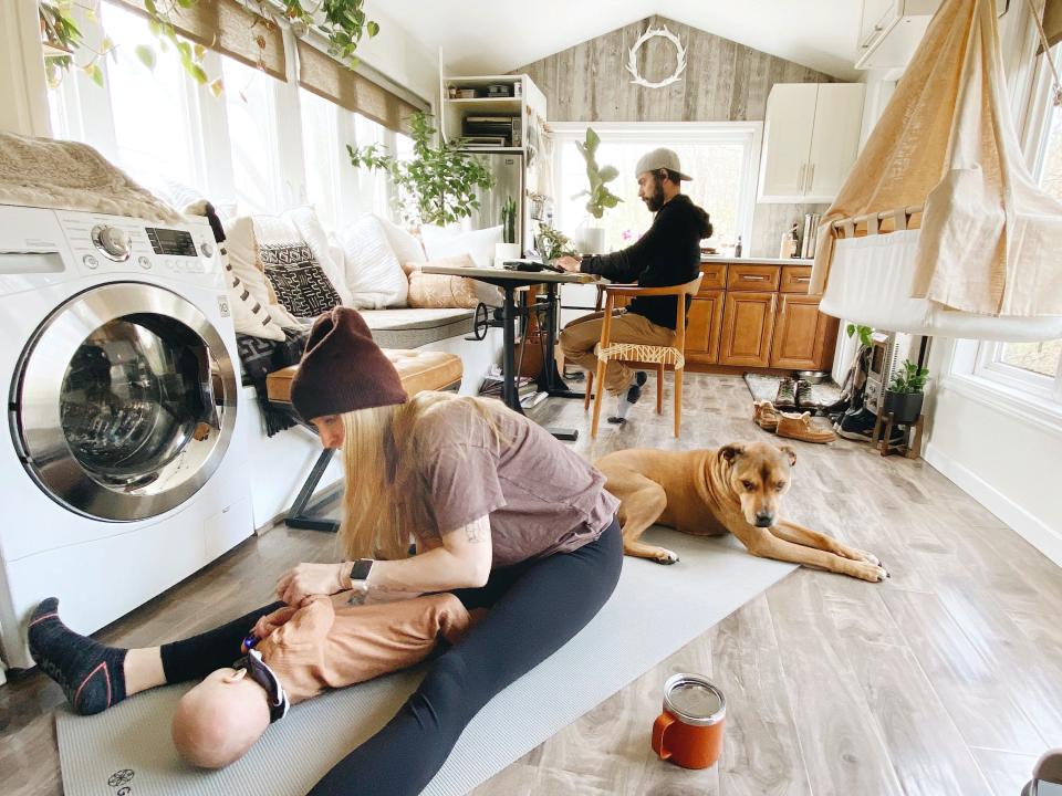 Interior of Shannon Soine's tiny house with baby, dog, and partner in the living room