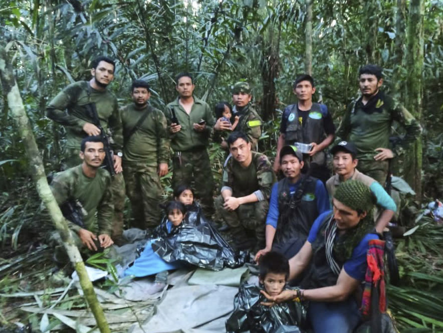 Soldiers and Indigenous men pose for a photo with the four Indigenous siblings who were missing after a deadly plane crash, in the Solano jungle, Caqueta state, Colombia, Friday, June 9, 2023. (Colombia's Armed Force Press Office via AP)