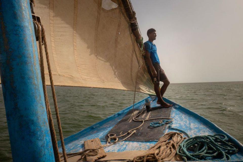 A fisherman stands at the front of a sailboat n the Banc d'Arguin National Park, Mauritania - Friday 19 July 2024