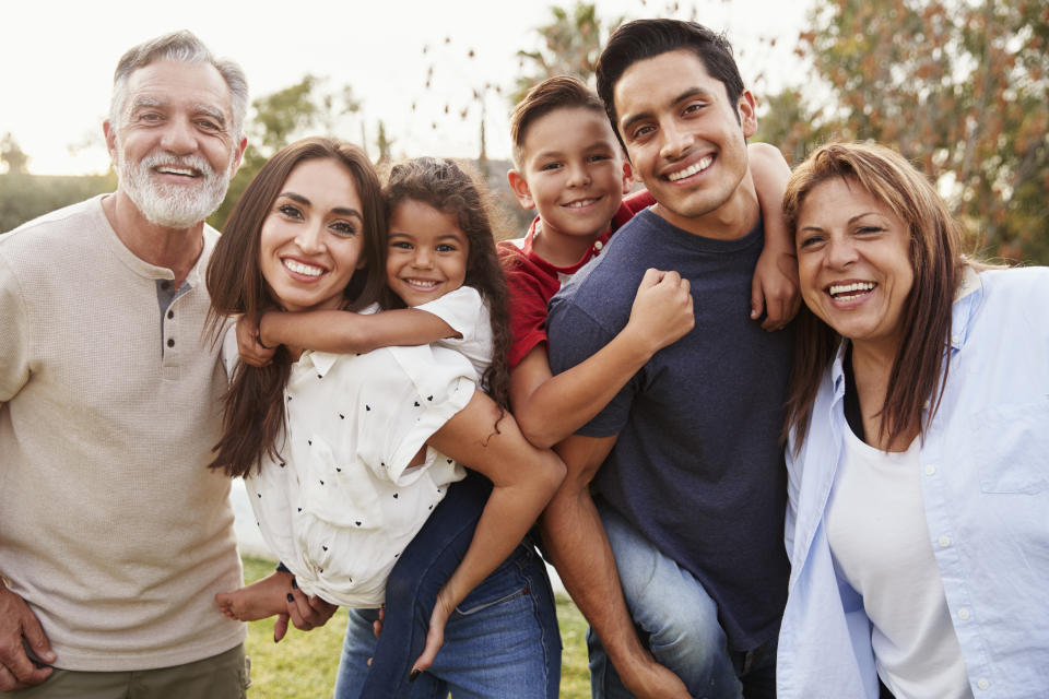 Parkinson's Three generation Hispanic family standing in the park, smiling to camera, selective focus