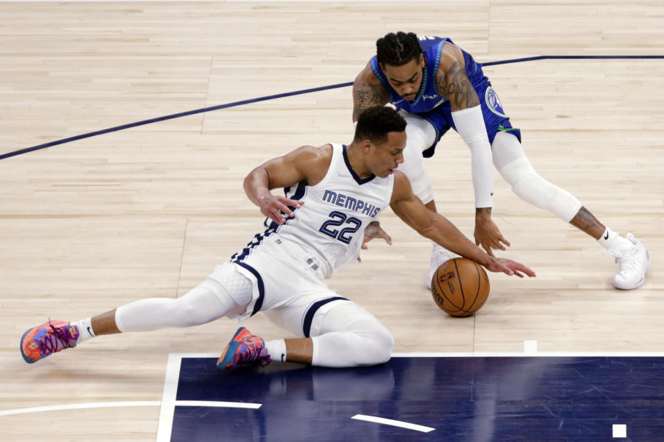 Memphis Grizzlies guard Desmond Bane (22) reaches for the ball against Minnesota Timberwolves guard D'Angelo Russell (0) during the first half in Game 6 of an NBA basketball first-round playoff series Friday, April 29, 2022, in Minneapolis. (AP Photo/Andy Clayton-King)