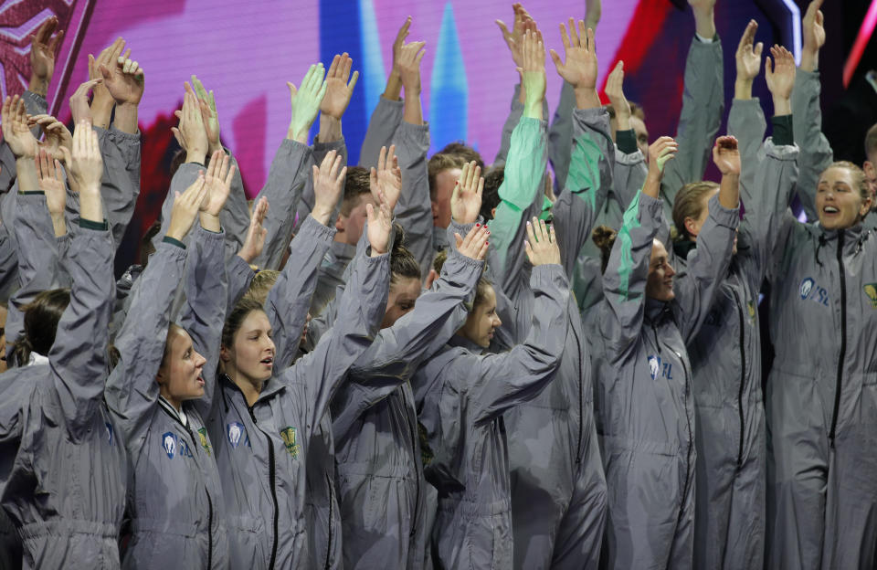 Members of the London Roar team celebrate as they are introduced before an International Swimming League event Friday, Dec. 20, 2019, in Las Vegas. (AP Photo/John Locher)