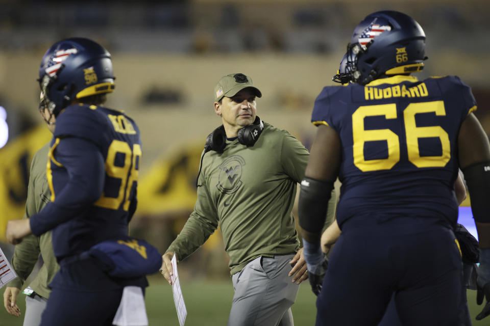 West Virginia head coach Neal Brown speaks with his team during the second half of an NCAA college football game against BYU on Saturday, Nov. 4, 2023, in Morgantown, W.Va. West Virginia won 37-7. (AP Photo/Chris Jackson)
