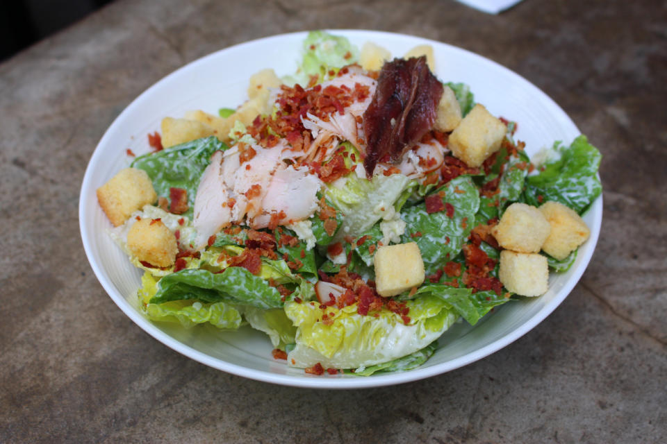 The only cold dish on the cheese wheel menu, the Caesar salad ($19) is mixed with a D10 classic dressing before being topped with croutons, smoked chicken and bacon bits. (Photo: Yahoo Singapore)