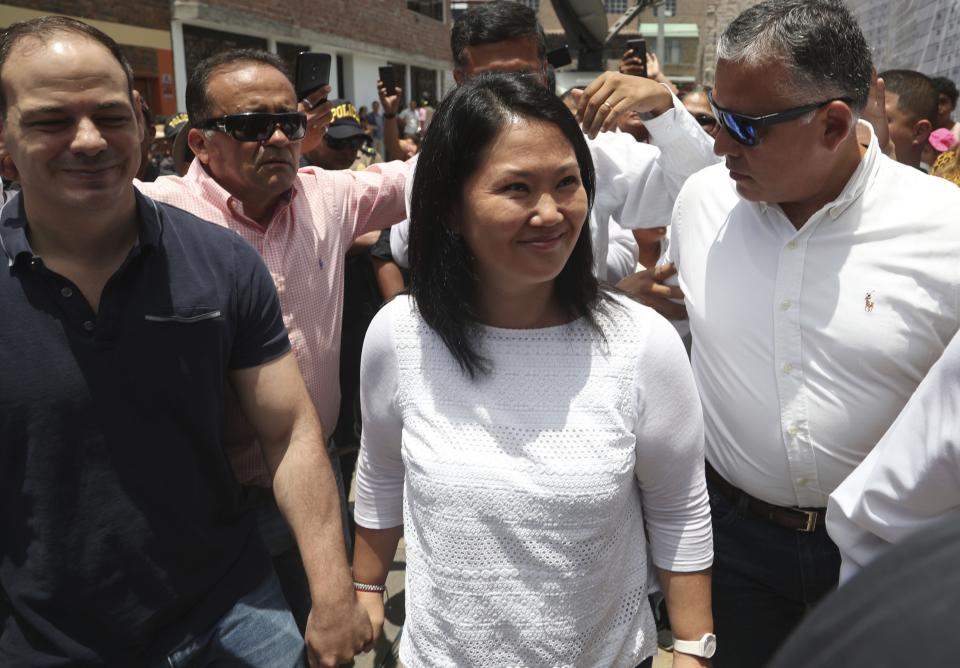 Keiko Fujimori, the daughter of Peru's former President Alberto Fujimori, and leader of the opposition party, center, with her husband Mark Vito Villanela, left, arrive to vote during congressional elections in Lima, Peru, Sunday, Jan. 26, 2020. Peruvians are voting to elect 130 new members of the congress that will legislate for only one year in place of the congress that was dissolved by president Martin Vizacarra in September 2019. (AP Photo/Martin Mejia)