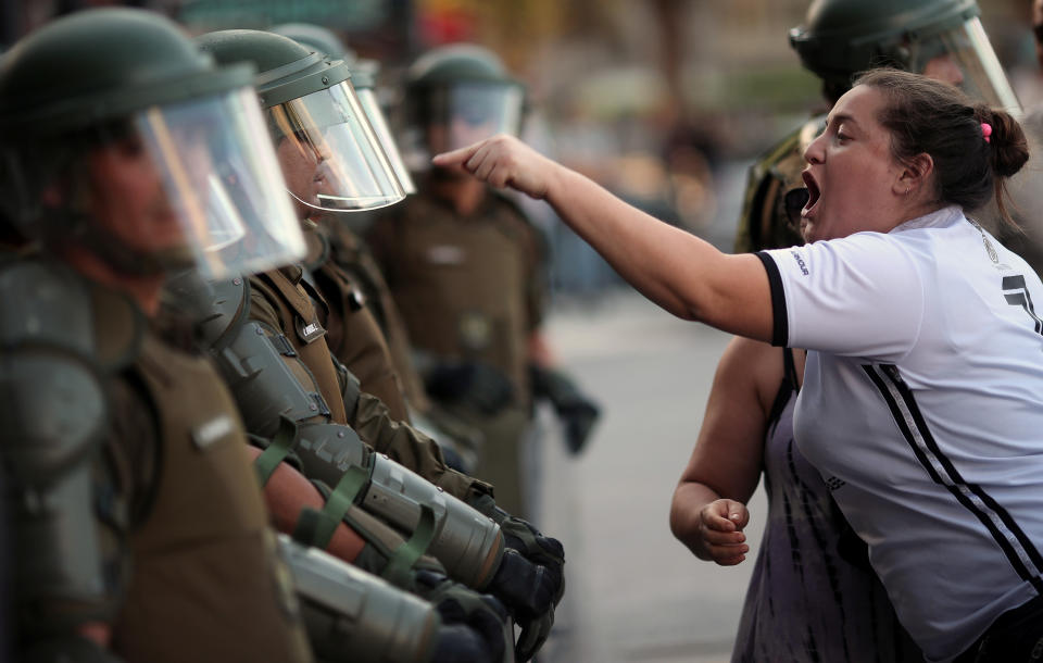 A woman argues with a riot policeman during a protest against Chile's government in Santiago, Chile December 15, 2019. REUTERS/Ricardo Moraes