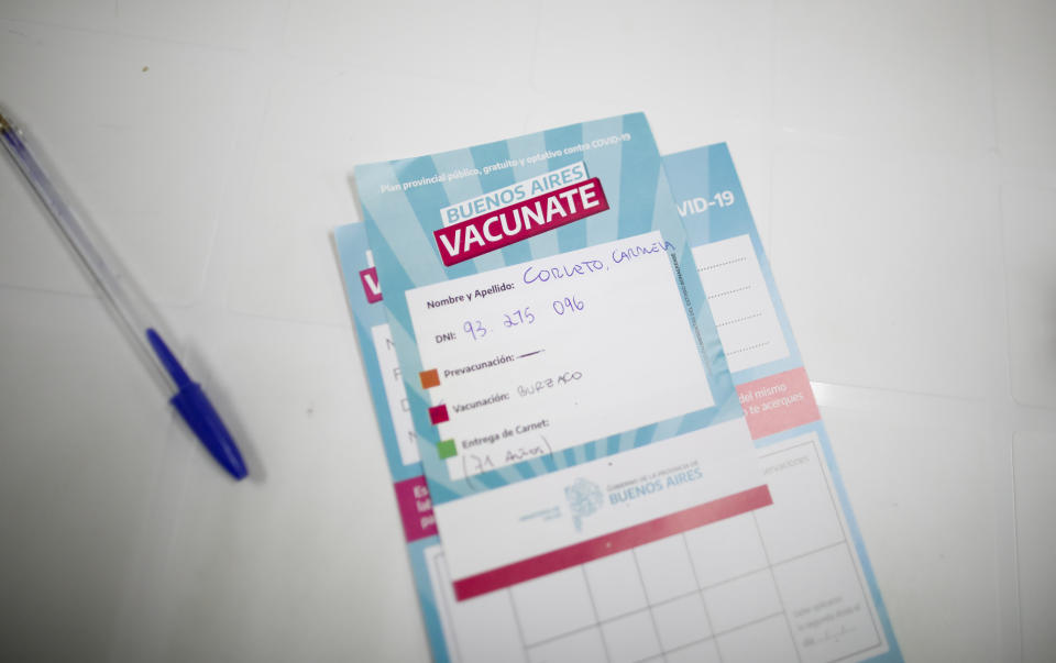 Carmela Corleto's vaccination certificate sits on a table after a nurse administered her first shot of the AstraZeneca vaccine for COVID-19 at a vaccination center in Almirante Brown, Argentina, Friday, April 23, 2021. (AP Photo/Natacha Pisarenko)