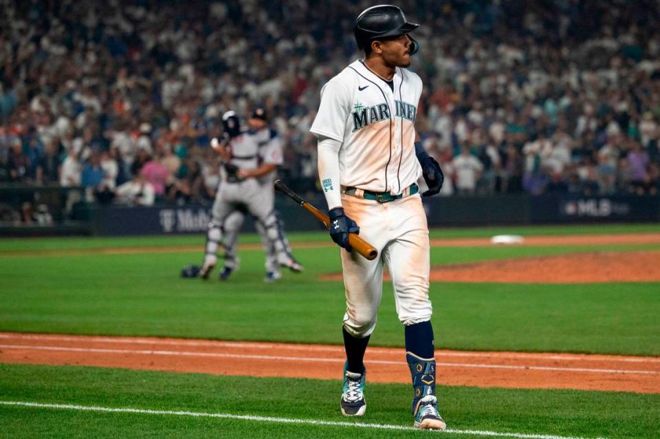 Houston Astros players celebrate as Seattle Mariners center fielder Julio Rodriguez (44) walks off the field after popping out to end the bottom of the 18th inning of game 3 of the ALDS on Saturday, Oct. 15, 2022, at T-Mobile Park in Seattle. Houston’s Jeremy Pena hit a solo home run in the top of the 18th inning to earn the Astros a sweep of the Mariners in the American League Divisional Series.