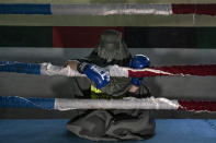 Afghan woman boxer poses for a photo in Kabul, Afghanistan, Saturday, Oct. 29, 2022. The ruling Taliban have banned women from sports as well as barring them from most schooling and many realms of work. A number of women posed for an AP photographer for portraits with the equipment of the sports they loved. Though they do not necessarily wear the burqa in regular life, they chose to hide their identities with their burqas because they fear Taliban reprisals and because some of them continue to practice their sports in secret. (AP Photo/Ebrahim Noroozi)