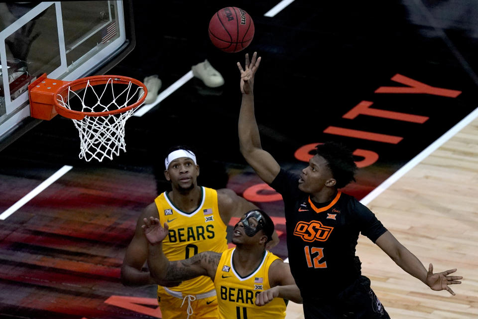 Oklahoma State's Matthew-Alexander Moncrieffe (12) shoots over Baylor's Mark Vital (11) and Flo Thamba (0) during the first half of an NCAA college basketball game in the semifinals of the Big 12 tournament in Kansas City, Mo., Friday, March 12, 2021. (AP Photo/Charlie Riedel)