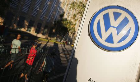 Workers walk past a Volkswagen logo at the Volkswagen plant in Sao Bernardo do Campo, near Sao Paulo January 8, 2015. REUTERS/Nacho Doce