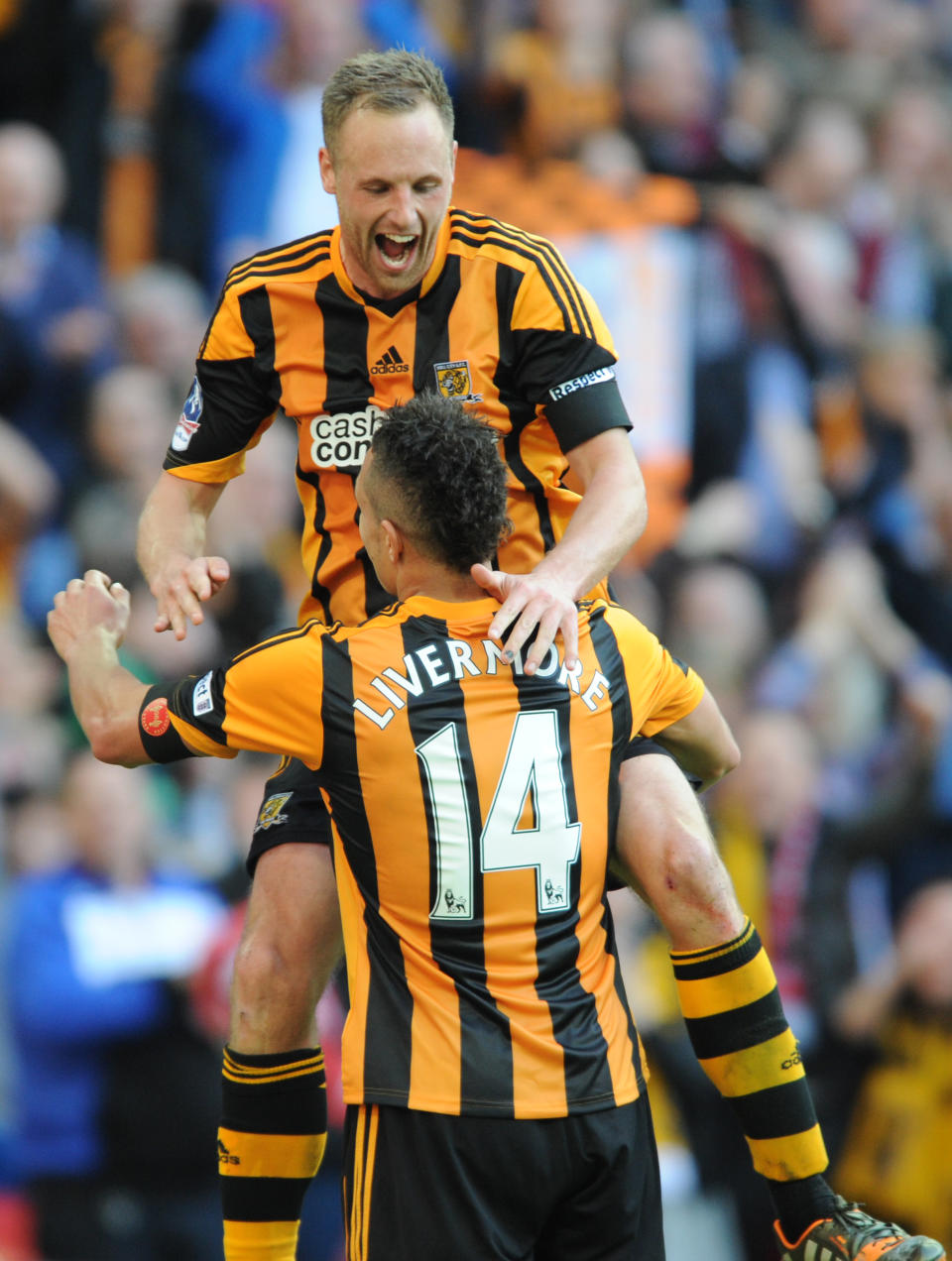 Hull City's David Meyler, top, celebrates with teammate Jake Livermore after scoring against Sheffield United during their English FA Cup semifinal soccer match between Hull City and Sheffield United at Wembley Stadium, London, England, Sunday, April 13, 2014. (AP Photo/Rui Vieira)