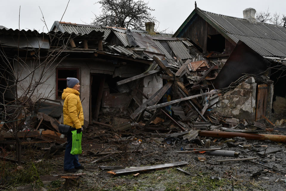 A woman stands near debris of her house following Wednesday's Russian shelling, in Kurakhove, Donetsk region, Ukraine, Thursday, Dec. 8, 2022. (AP Photo/Andriy Andriyenko)