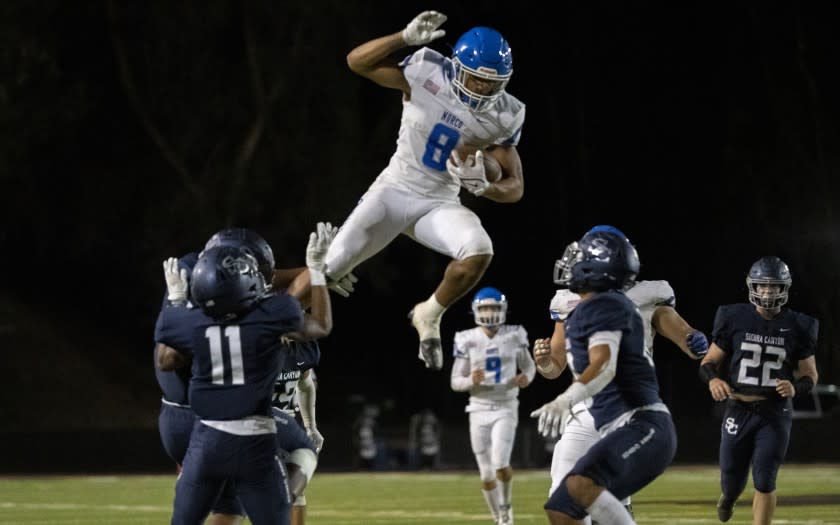 CALABASAS, CA - SEPTEMBER 24, 2021: Norco running back Jaydn Ott (8) tries to leap over Sierra Canyon defenders Darryl West (11) and Micah Valenzuela (10) in the first half at Calabasas High School at on September 24, 2021 in Calabasas, California.(Gina Ferazzi / Los Angeles Times)