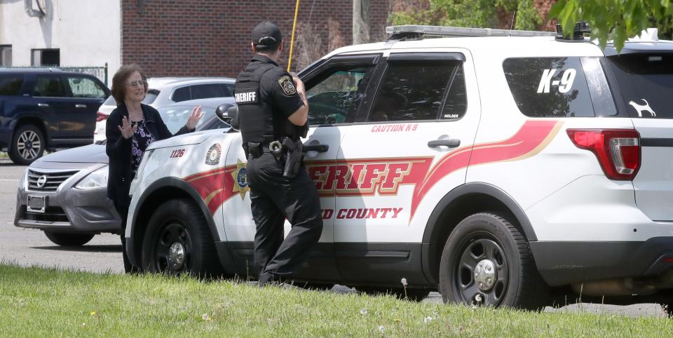 A passer-by talks to a Rockland County Sheriff Officer stationed at the Armani Hotel in Orangeburg May 10, 2023.