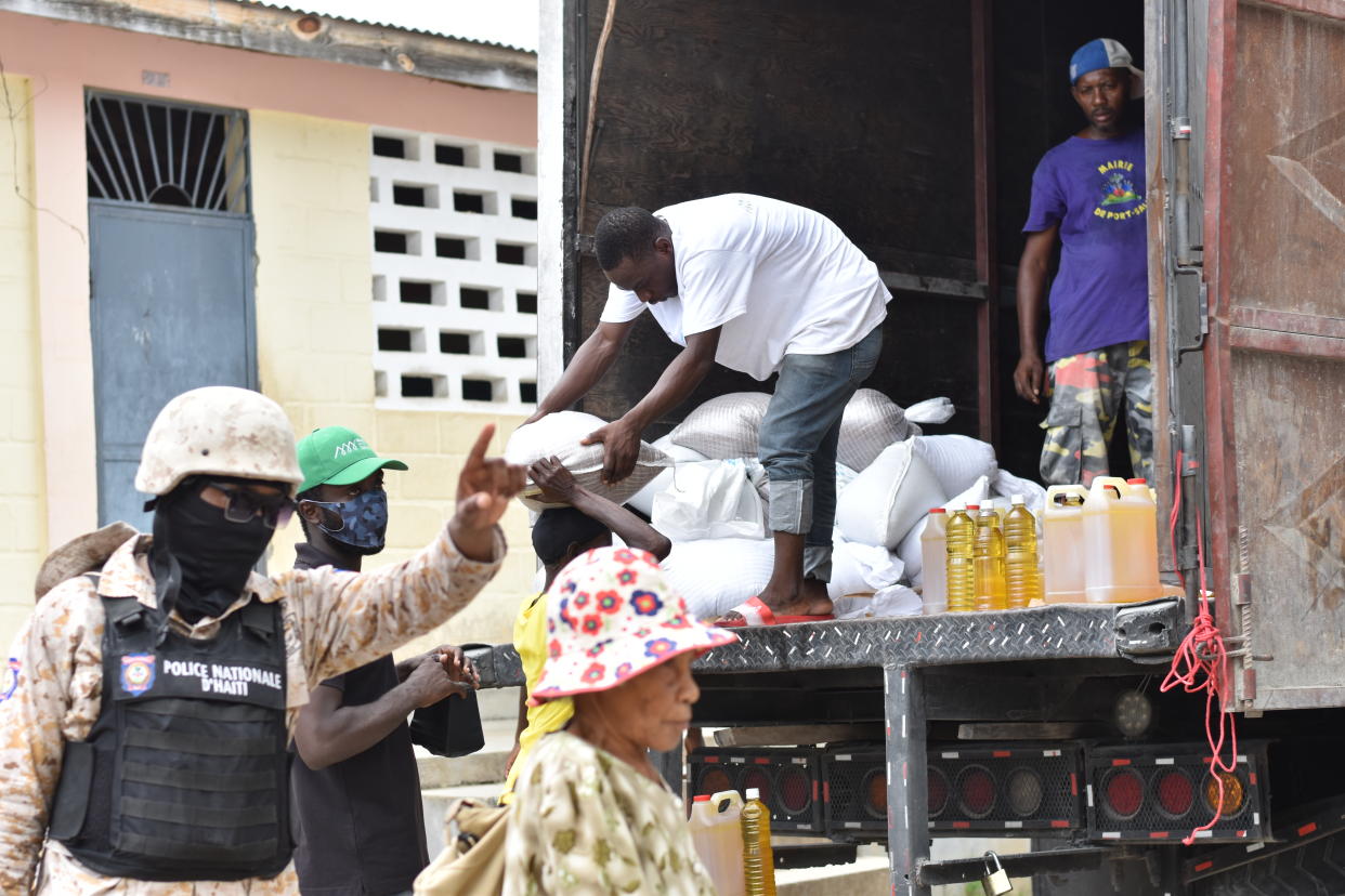 A member of the Haitian National Police (PNH) directs residents 