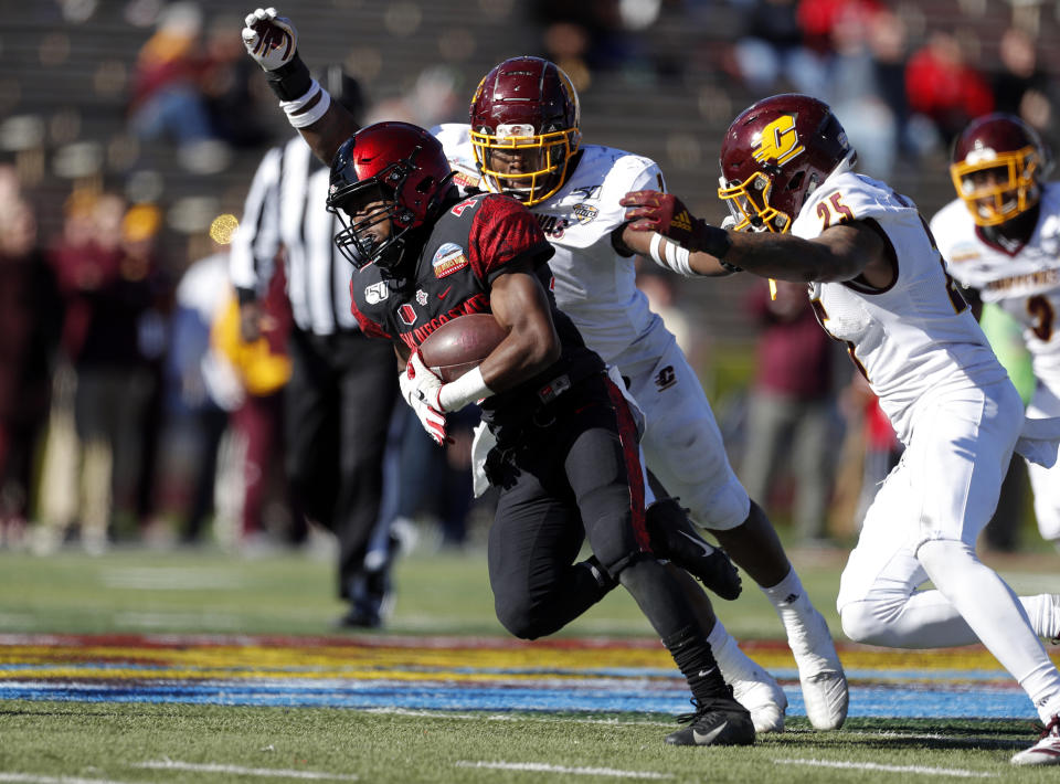 San Diego State wide receiver BJ Busbee, left, tries to break away from Central Michigan linebacker Michael Oliver (7) and defensive back Dishon McNary (25) during the first half of the New Mexico Bowl NCAA college football game on Saturday, Dec. 21, 2019 in Albuquerque, N.M. (AP Photo/Andres Leighton)