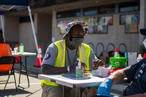 An AmeriCorps member serving with the National Civilian Community Corps currently deployed to support vaccination efforts in California works the check-in desk at a mobile vaccine clinic in Alameda County.