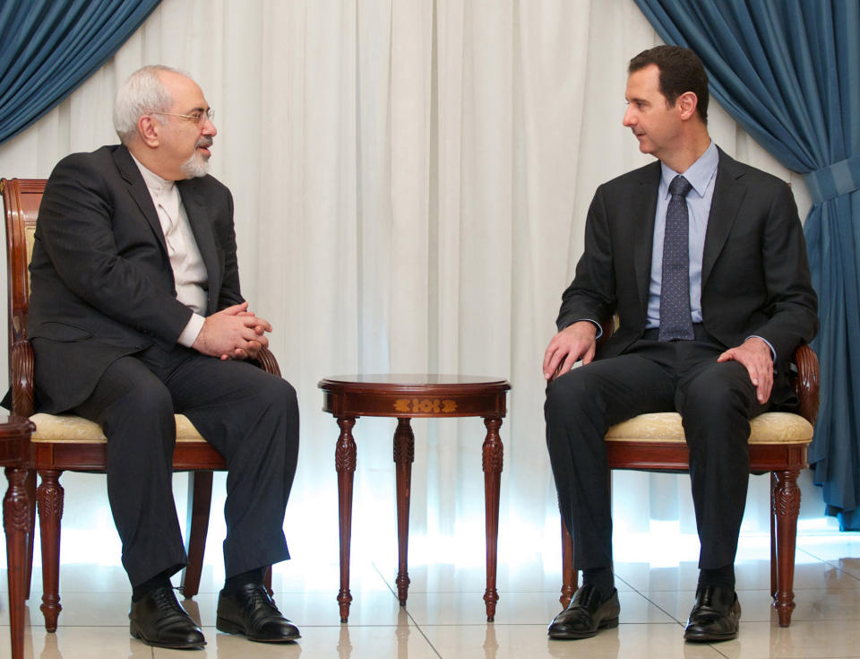 In this photo released by the Syrian official news agency SANA, Iranian Foreign Minister Mohammad Javad Zarif, left, meets with Syrian President Bashar Assad, right, in Damascus, Syria, Wednesday, Jan. 15, 2014. Assad and Zarif have held talks about next week's United Nations conference in Montreux, Switzerland, aimed at trying to resolve the three-year deadly conflict. (AP Photo/SANA)