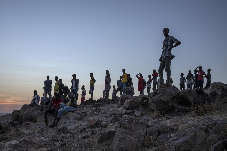 Tigray people who fled the conflict in Ethiopia's Tigray region, stand on a hill top over looking Umm Rakouba refugee camp in Qadarif, eastern Sudan, Thursday, Nov. 26, 2020. Ethiopia's prime minister said Thursday the army has been ordered to move on the embattled Tigray regional capital after his 72-hour ultimatum ended for Tigray leaders to surrender, and he warned the city's half-million residents to stay indoors and disarm. (AP Photo/Nariman El-Mofty)