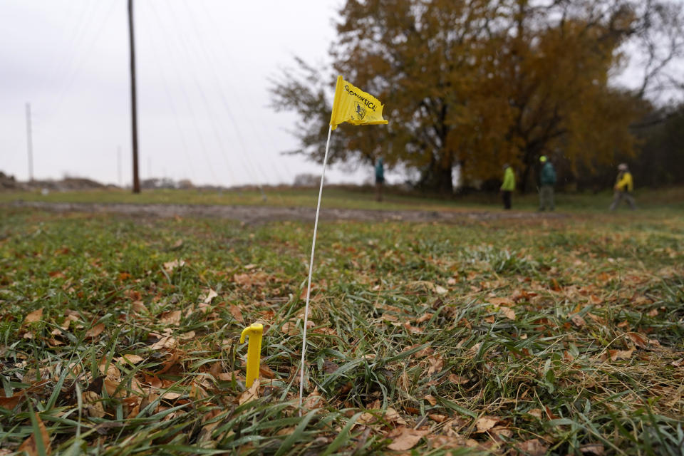 A flag marks a spot where a team affiliated with the National Park Service use ground-penetrating radar in hopes of detecting what is beneath the soil while searching for over 80 Native American children buried at the former Genoa Indian Industrial School, Thursday, Oct. 27, 2022, in Genoa, Neb. For decades the location of the student cemetery has been a mystery, lost over time after the school closed in 1931 and memories faded of the once-busy campus that sprawled over 640 acres in the tiny community of Genoa. (AP Photo/Charlie Neibergall)