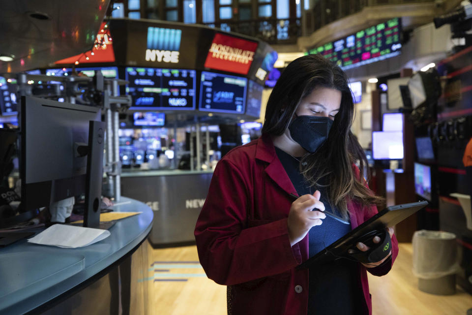 In this photo provided by the New York Stock Exchange, trader Ashley Lara works on the trading floor, Tuesday, Jan. 12, 2021. U.S. stocks are drifting near their record heights Tuesday, while Treasury yields keep marching higher amid expectations that the economy will pull out of its slump after a powerful recovery sweeps the globe later this year. (Colin Ziemer/New York Stock Exchange via AP)