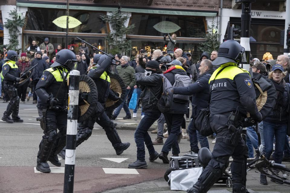 Police clash with demonstrators as thousands of people defied a ban Sunday to gather and protest the Dutch government's coronavirus lockdown measures, in Amsterdam, Netherlands, Sunday, Jan. 2, 2022. The municipality of the Dutch capital banned the protest, saying police had indications some demonstrators could be attending "prepared for violence." (AP Photo/Peter Dejong)