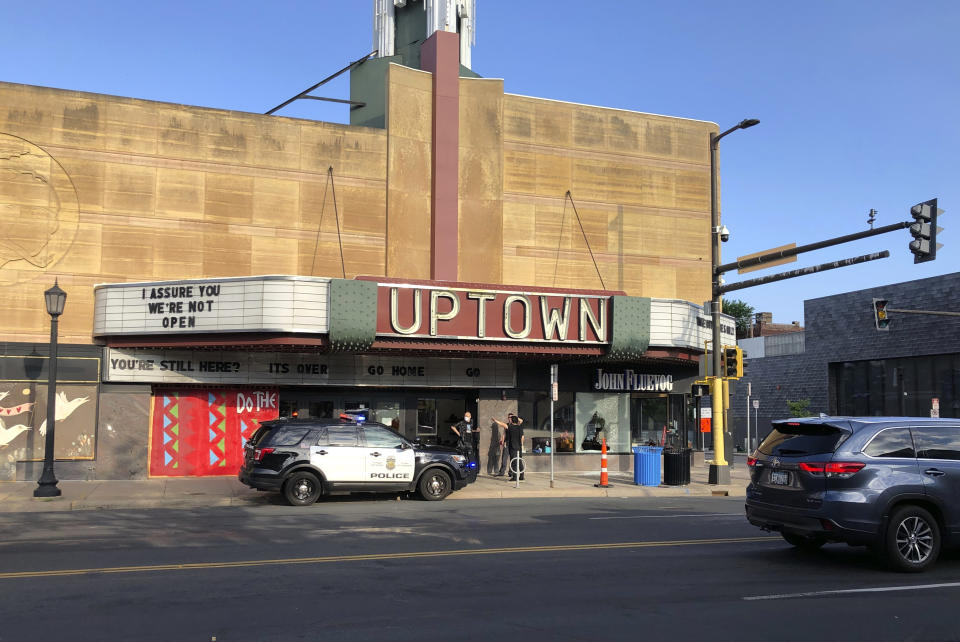 A police vehicle is parked outside the Uptown Theatre Sunday, June 21, 2020, following a shooting in Minneapolis' Uptown neighborhood. Multiple people were shot, one fatally, when gunfire broke out shortly after midnight Sunday. (AP Photo/Doug Glass)