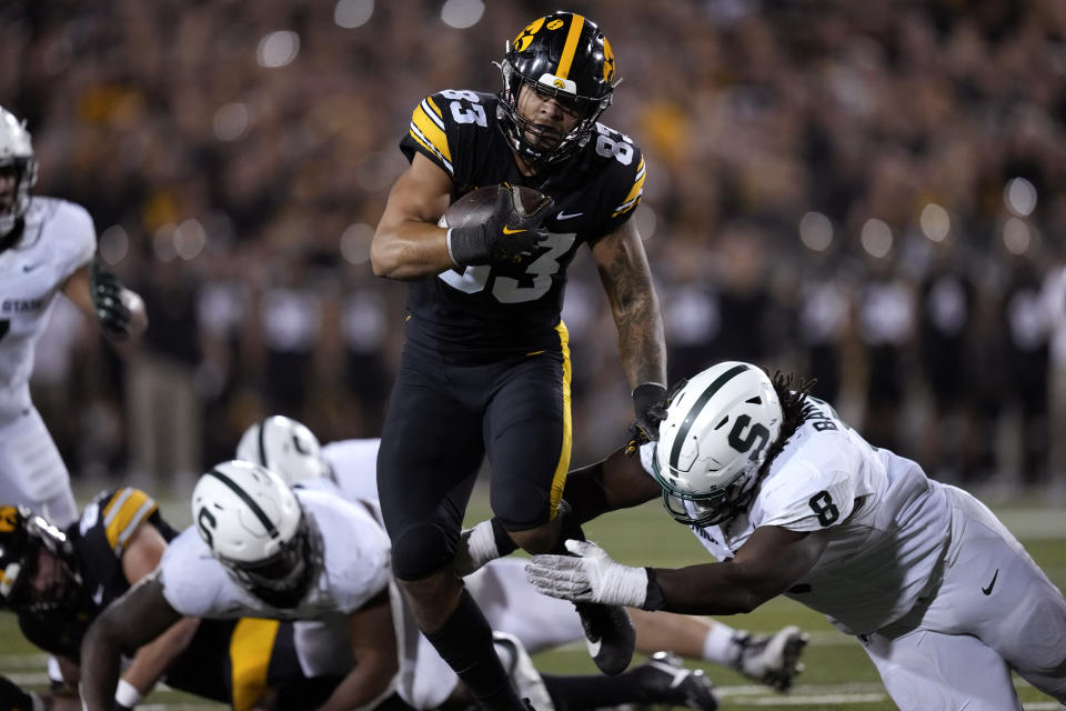 Iowa tight end Erick All (83) breaks a tackle by Michigan State defensive lineman Simeon Barrow Jr. (8) during a 13-yard touchdown reception in the first half of an NCAA college football game, Saturday, Sept. 30, 2023, in Iowa City, Iowa. (AP Photo/Charlie Neibergall)