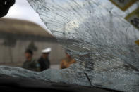 Security personnel inspect the site of a deadly bomb attack in Kabul, Afghanistan, Sunday, March 7, 2021. The bomb attached to minibus exploded Sunday in the capital, Kabul, killing and wounding several people. (AP Photo/Rahmat Gul)