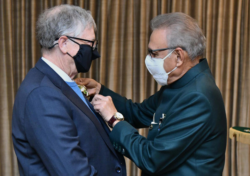 In this photo released by Pakistan's Press Information Department, Pakistan's President Arif Alvi, right, awards the country's second highest civilian award, Hilal-e-Pakistan, to the Microsoft co-founder and billionaire philanthropist Bill Gates at a ceremony, in Islamabad, Pakistan, Thursday, Feb. 17, 2022. Pakistan awarded Gates in recognition of his work to alleviate poverty and diseases like polio and tuberculosis. (Press Information Department via AP)