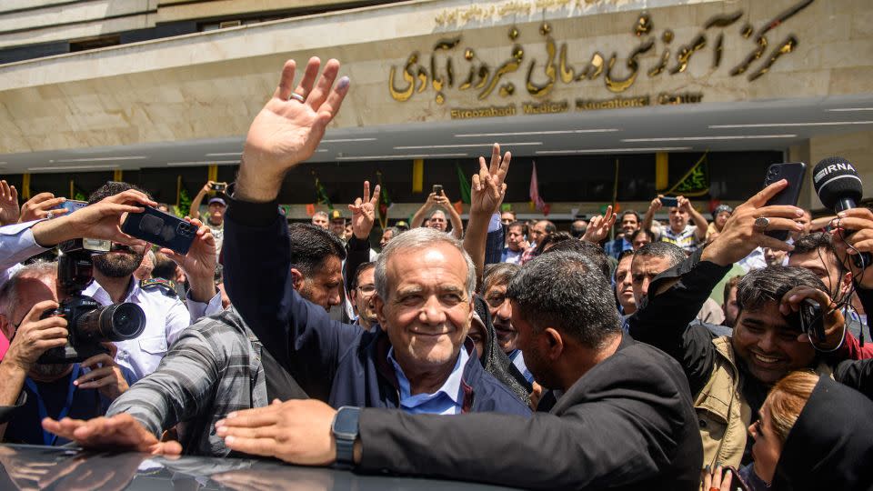 Masoud Pezeshkian, Iranian presidential election candidate and lawmaker waves to the crowd after casting his vote at a polling station in Tehran, Iran on Friday. - Hossein Beris/Middle East Images/AFP/Getty Images