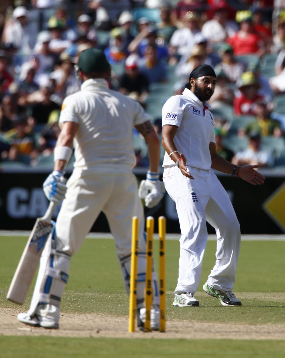 England's Monty Panesar (R) celebrates after taking the wicket of Australia's captain Michael Clarke during the third day's play in the second Ashes cricket test at the Adelaide Oval December 7, 2013.