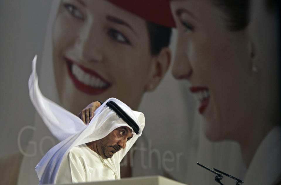 Sheik Ahmed bin Saeed Al Maktoum, Emirates' chairman and CEO, fixes his Ghutra, a traditional men's head scarf, during a news conference in Dubai, United Arab Emirates, Thursday, May 8, 2014. The parent company of the Middle East's biggest airline, Emirates, posted an annual profit Thursday of $1.1 billion as it enjoyed a dip in fuel costs and boosted capacity with the addition of two dozen new planes. (AP Photo/Kamran Jebreili)