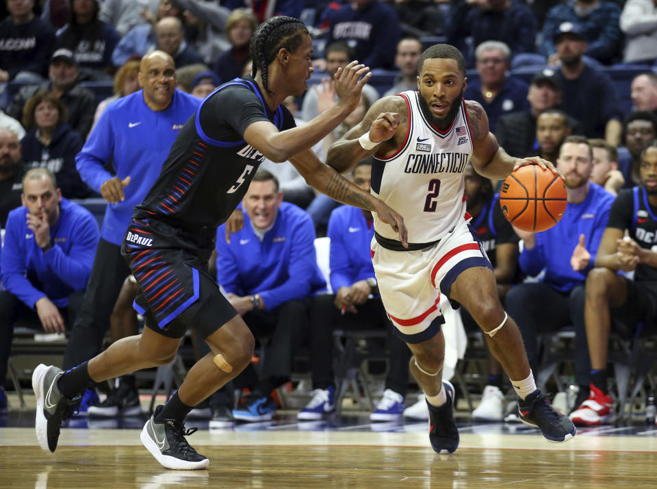 Connecticut's R.J. Cole (2) drives to the basket against the defense of DePaul's Philmon Gebrewhit (5) during the first half of an NCAA college basketball game Saturday, March 5, 2022, in Storrs, Conn. (AP Photo/Stew Milne)