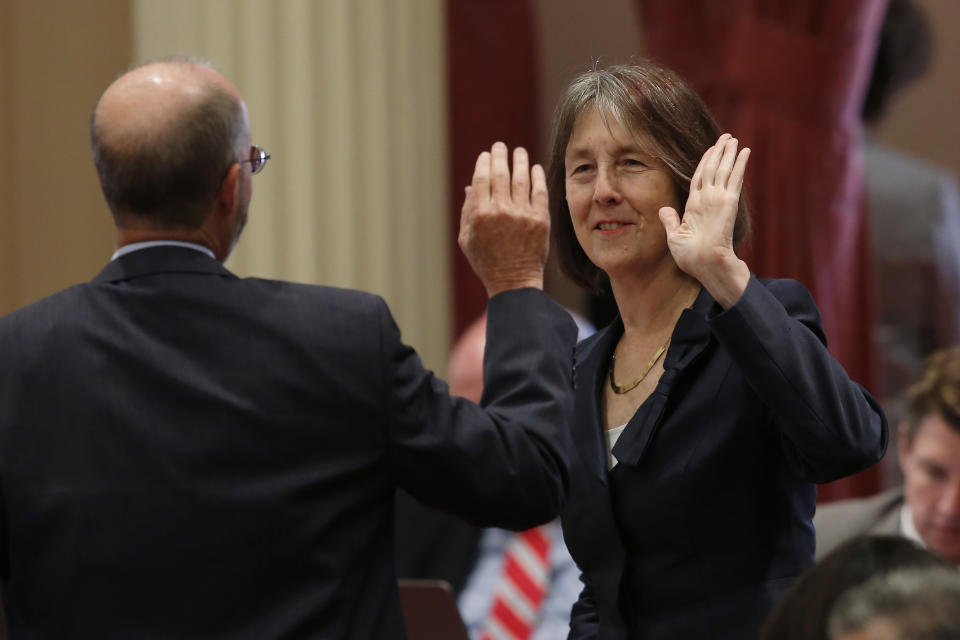 FILE - Sen. Nancy Skinner, D-Berkeley and state Sen. Steven Glazer, D-Orinda slap palms in celebration after her measure to let athletes at California colleges hire agents and sign endorsement deals was approved by the Senate in Sacramento, Calif., Sept. 11, 2019. A California lawmaker introduced a bill Thursday, Jan. 19, 2023, that would require schools that play major college sports to pay some athletes as much as $25,000 annually, along with covering the cost of six-year guaranteed athletic scholarships and post-college medical expenses. (AP Photo/Rich Pedroncelli, File)