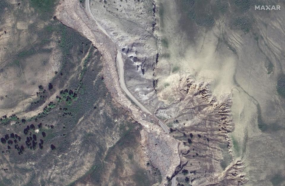 satellite image shows mountain road with large sections crumbled away alongside grey brown river