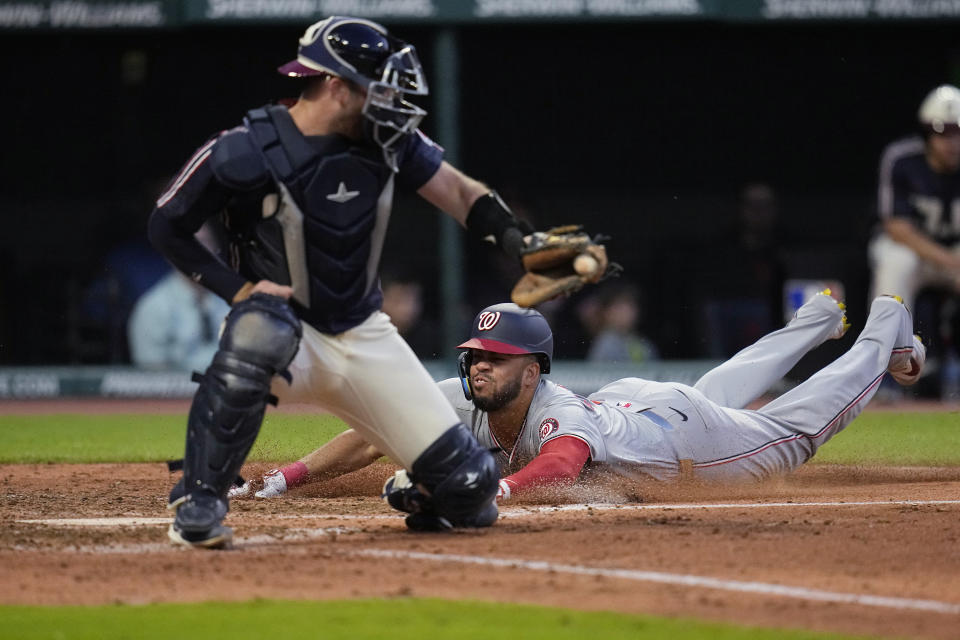 Washington Nationals' Luis García Jr. scores behind Cleveland Guardians cather David Fry during the seventh inning of a baseball game Friday, May 31, 2024, in Cleveland. (AP Photo/Sue Ogrocki)