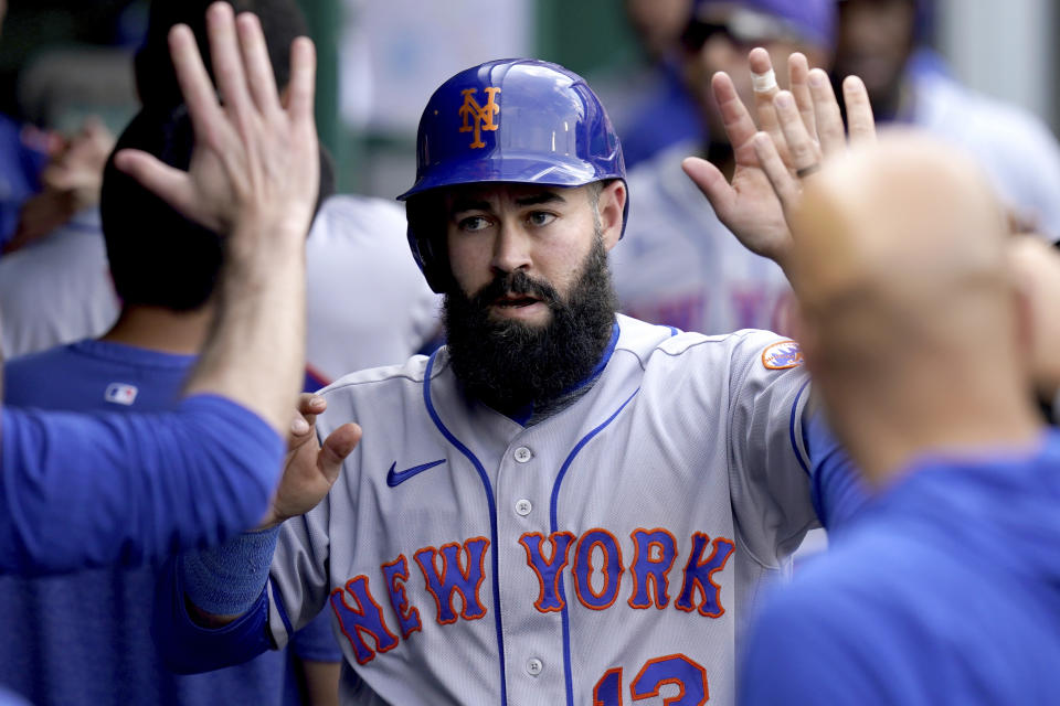 New York Mets' Luis Guillorme is congratulated in the dugout after scoring against the Pittsburgh Pirates in the seventh inning of a baseball game in Pittsburgh, Saturday, June 10, 2023. (AP Photo/Matt Freed)