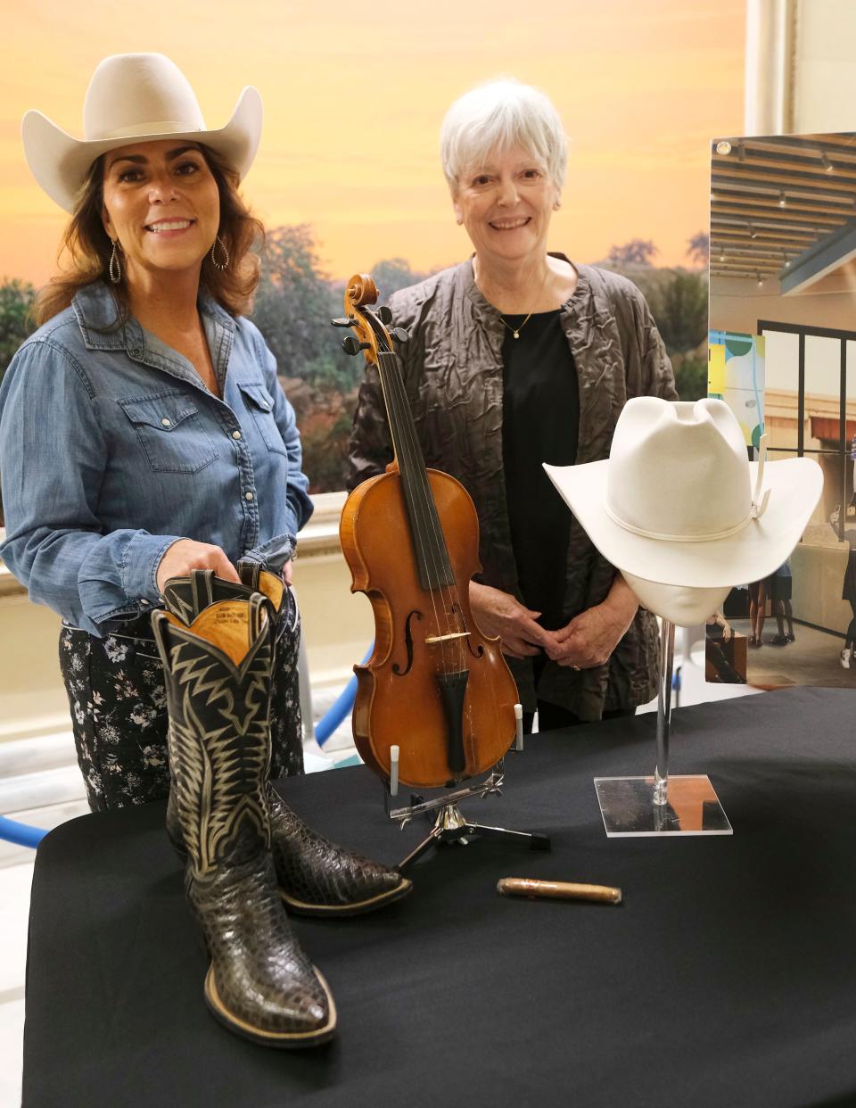 From left, Andrea Ruby, Bob Wills' granddaughter, and Carolyn Wills, his daughter, pose with Bob Wills memorabilia at he OKPOP table at Bob Wills Day at the state Capitol Monday, March 6, 2023, in Oklahoma City.