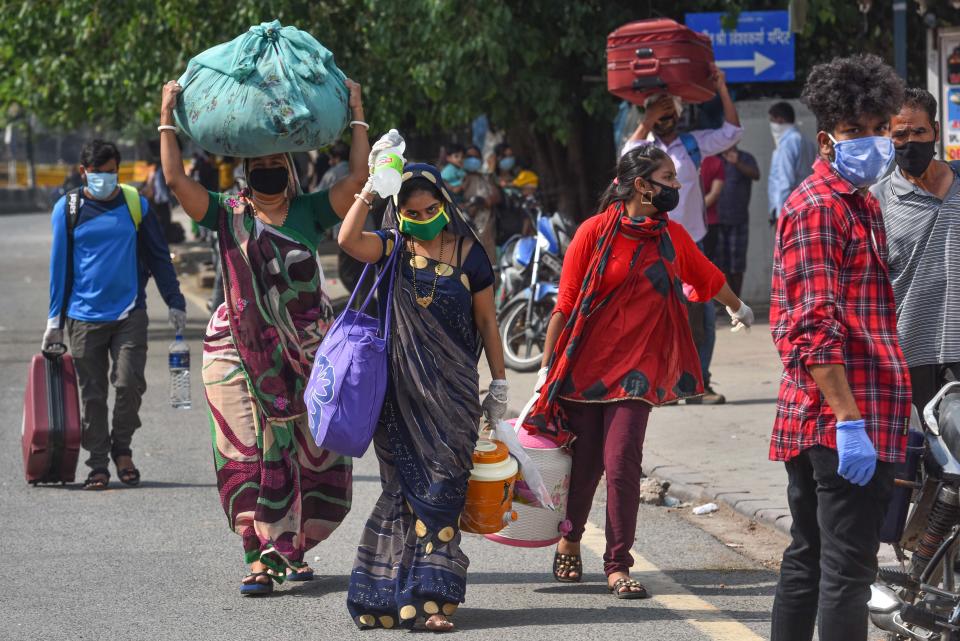 NEW DELHI, INDIA - MAY 13: Migrant workers arrive at the New Delhi Railway Station to board a special train bound to their native state, during lockdown, on May 13, 2020 in New Delhi, India. (Photo by Sanchit Khanna/Hindustan Times via Getty Images)