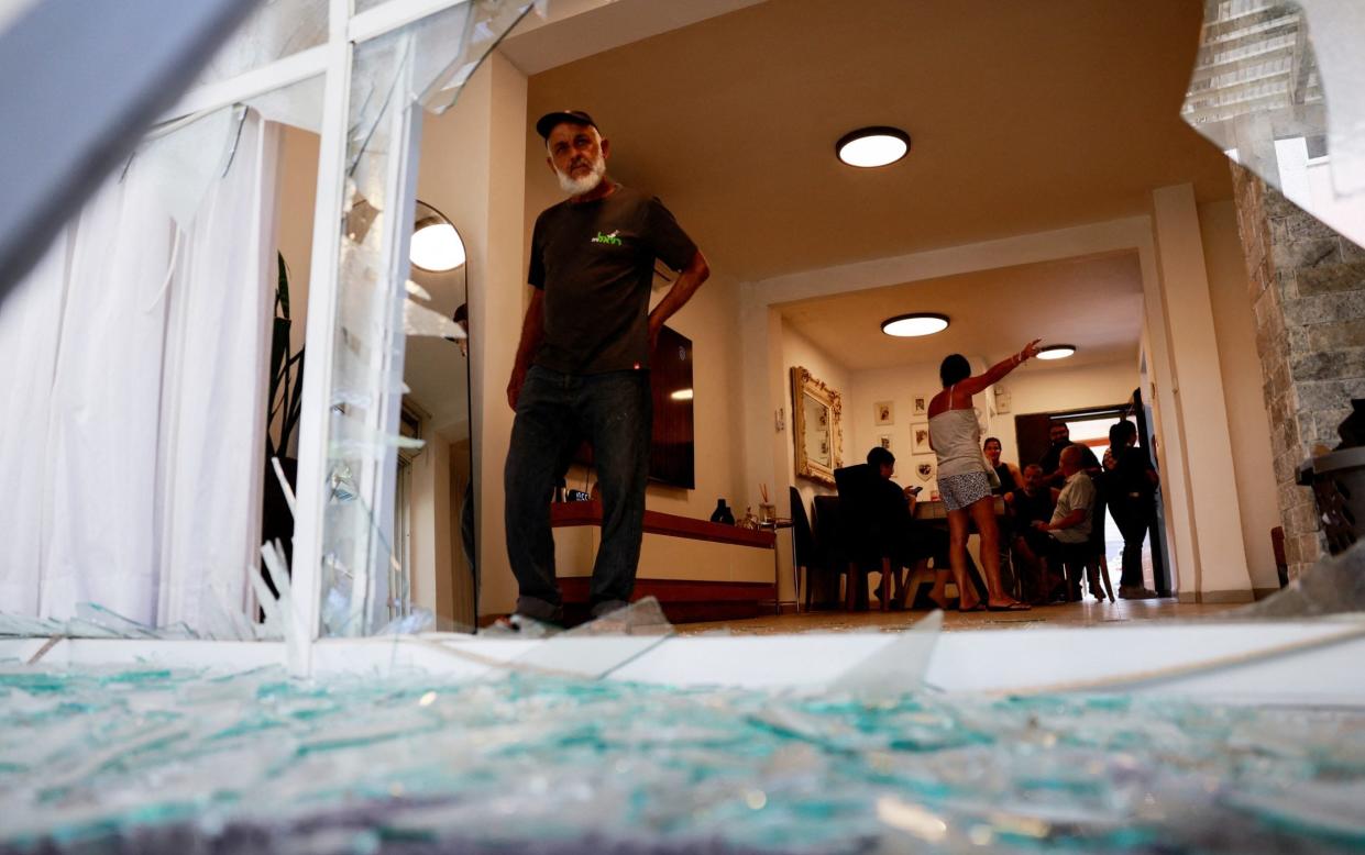 Man stands in residential building damaged by Hezbollah rockets in Acre, northern Israel